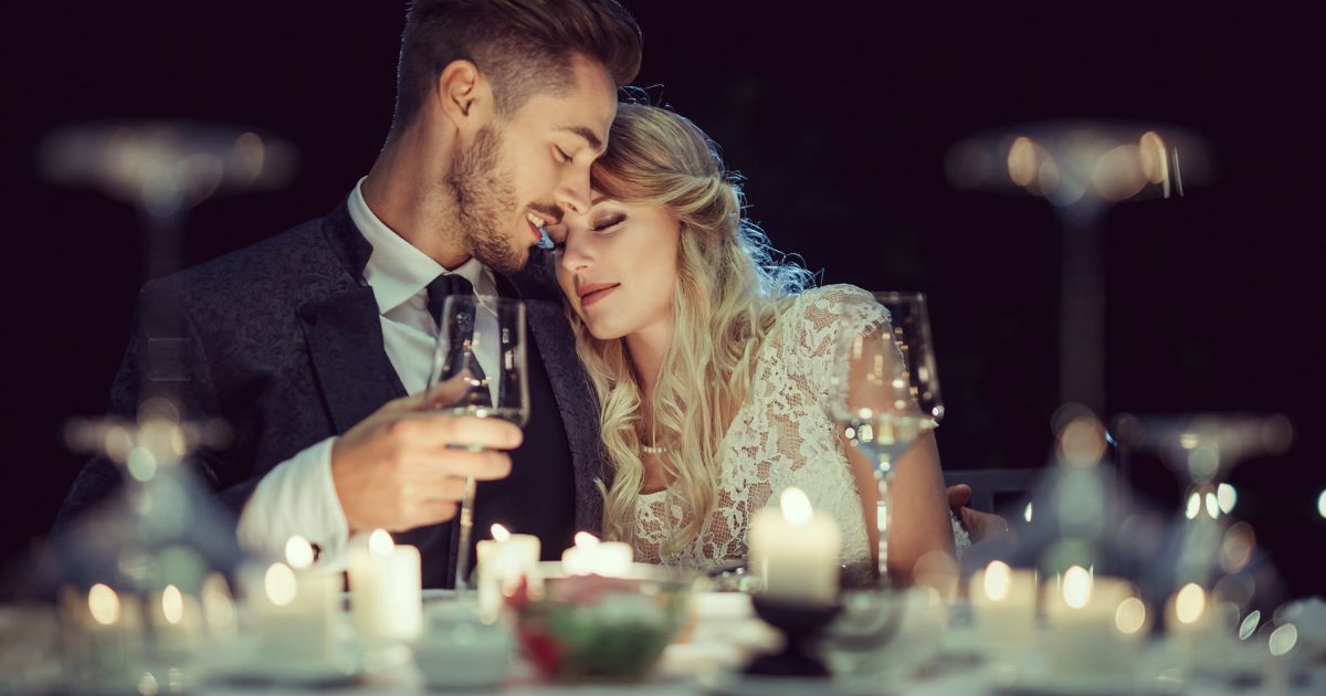 Bride and groom at a wedding reception table set with red and white wines