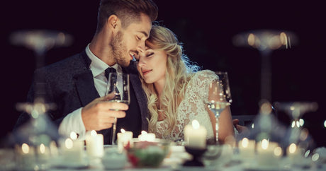 Bride and groom at a wedding reception table set with red and white wines