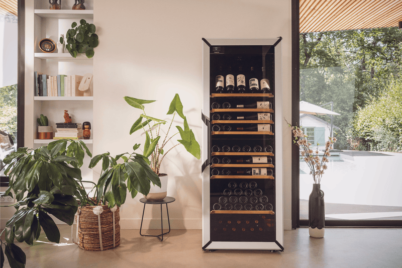 Goguette Wine Fridge Large Unit 150 Bottles White in an apartment with plants and books, the unit has a display row